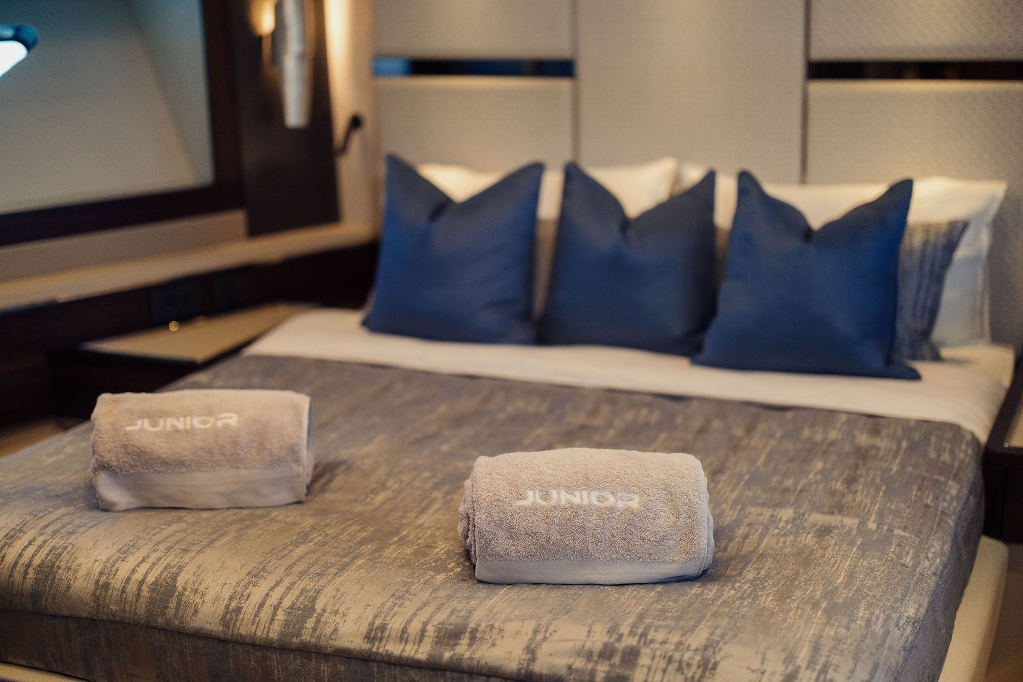 M/Y Lio Black Knight Sunseeker 95 master cabin with branded towels — luxury charter details