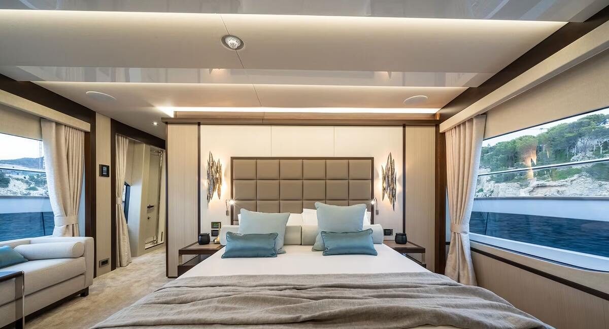 Couple enjoying morning in master cabin of M/Y Lio Black Knight Sunseeker 95 — charter accommodation