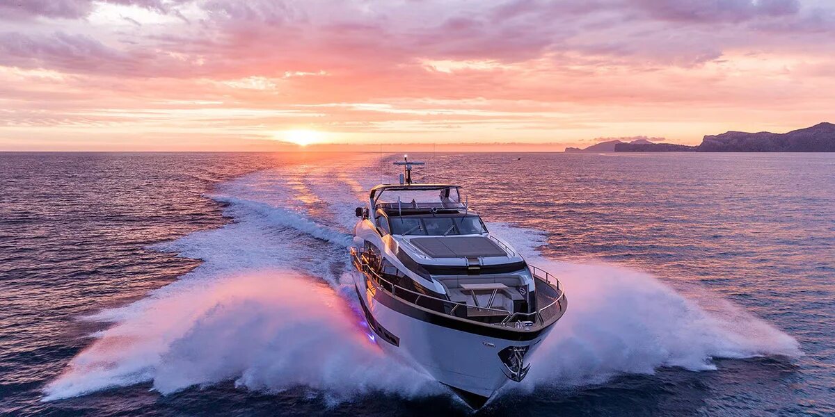 M/Y Lio Black Knight Sunseeker 95 illuminated at sunset with underwater lights — luxury yacht charter Palma de Mallorca